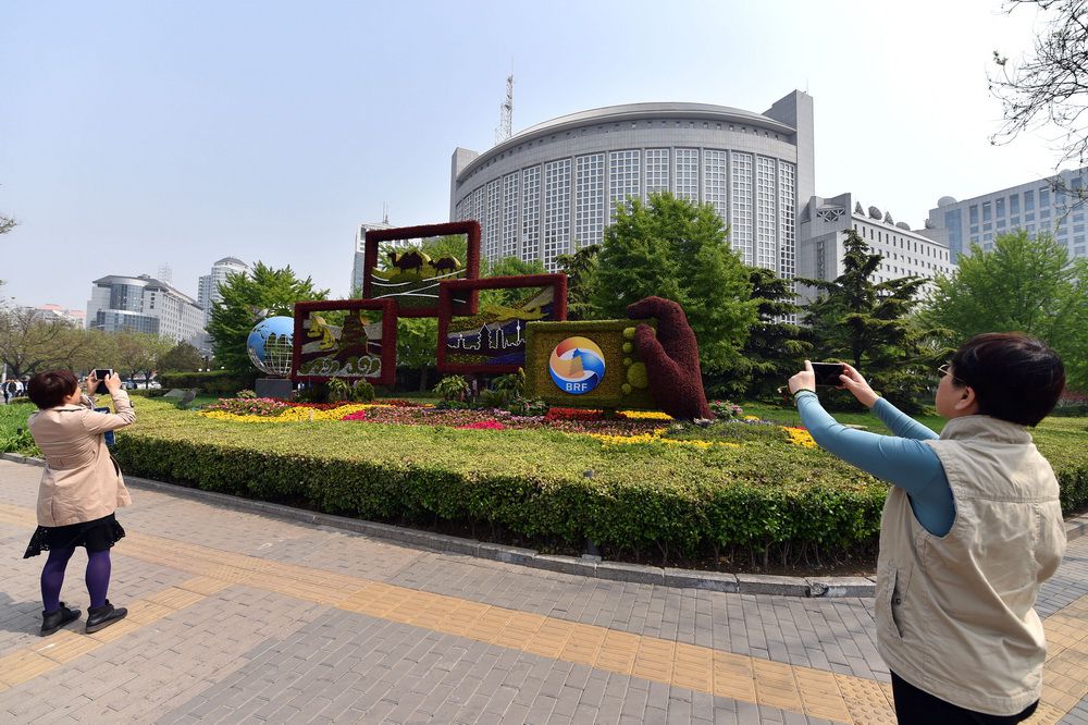 4月17日，路人用手机拍摄一带一路主题花坛。
